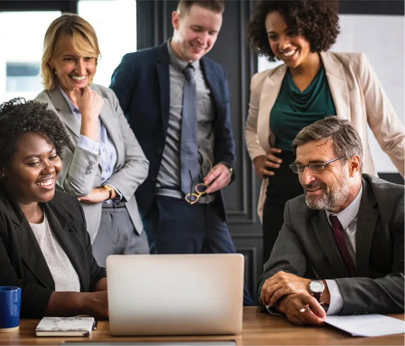 Marketing team collaborating around a laptop